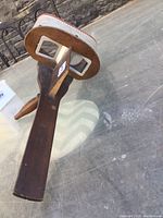 Side view showing the wooden handle and dual glass lenses of the stereoscope viewer.