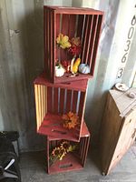 Three red painted wood crates stacked with fall decor inside, showing size and style.