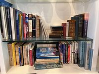 Front and partial side views of two shelves filled with a variety of books including titles on national parks, military history, and spirituality.