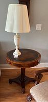 Full view of round-top mahogany side table supporting alabaster lamp with pleated shade