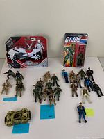 Lot of various military figures and vehicles arranged on table with note cards describing some items