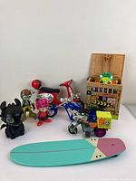 Overview of lot including toy motorcycles, figures, crate, and surfboard