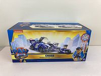 Full front view of the new sealed box featuring Paw Patrol Chase Transforming City Cruiser toy with cityscape backdrop and branding.