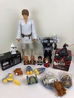 Wide shot of lot contents including large Luke Skywalker figure, mini busts, multiple small figures, and Darth Vader/Anakin Transformer figure.