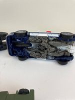Underside view of blue Transformers vehicle showing intricate mechanical and robotic plastic details