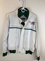 Front view of white jacket with green cuffs and collar, showing Castro GTX Racing embroidery on left chest.