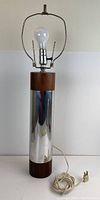 Side view of vintage Laurel table lamp showing full height, metal and wood finishes, light bulb in place, power cord coiled at base.
