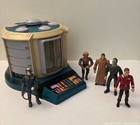 Photo showing the Star Trek Transporter Play Set and five action figures arranged to the right.
