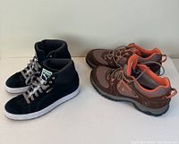 Both pairs of shoes displayed side by side showing Puma suede high tops and Garmont hiking boots
