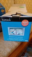 Photo of the Garmin nüvi 650 GPS device box front showing the device image, branding, and key features such as the 4.3 inch screen and travel assistant capabilities.