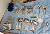 Full set of over 60 pieces of Kings Plate silver plate cutlery and serving utensils arranged on a cloth, showing knives, forks, spoons, tablespoons, and serving pieces.