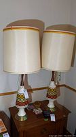 Two identical vintage Mid-Century Modern lamps approximately 40 inches tall with fabric shades and colorful geometric patterned resin bases.