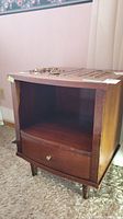 Front view of wooden night table showing cubbie and drawer