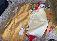 Photo showing a collection of aprons including a mustard yellow apron with turquoise trim and others.