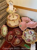 Three tier floral porcelain serving tray, pink three-section divided dish, and small floral sectioned dish on table