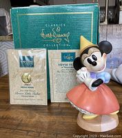 Figurine shown alongside original green Classics Collection box and certificate of authenticity in clear plastic holder with gold embossed Walt Disney seal.