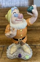 Front view of Royal Doulton Disney figurine 'Dear Old Doc' holding a green gem.