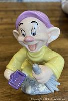 Front view of the Royal Doulton Disney figurine showing Dopey holding a bird and a birdhouse.
