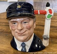 Front view of Toby Jug showing detailed facial expression and the train engineer's cap with railway symbol.
