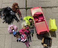 Seven LOL Surprise dolls in assorted styles and sizes alongside a pink coupe vehicle and a yellow slide accessory.