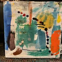 Close-up of one abstract acrylic painting with dominant green, blue, orange and red colors and brush strokes