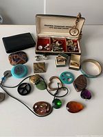 Overview of men’s jewelry assortment including rings, necklaces, cufflinks, bangle and jewelry box.