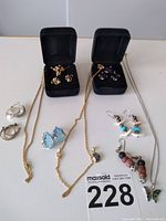 The entire collection showing all items including necklaces with pendants, various pairs of earrings in different styles and colors.
