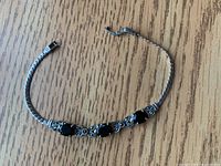 Sterling silver bracelet with three black stones and ornate silver detailing.