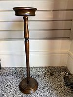 Full view of the wooden ashtray stand showing turned spindle design and round base