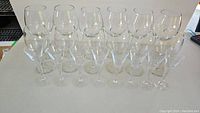 Front view of 20 wine and aperitif glasses arranged on table showing three rows of glasses.