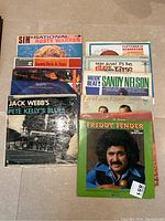 Photo of the lot showing 11 vintage vinyl record albums including Freddy Fender, Rusty Warren, Sammy Davis Jr., Sandy Nelson, and others.