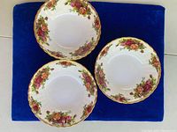 Top view of three of the six Royal Albert Old Country Roses bowls, showing the rose pattern and scalloped gold rim.