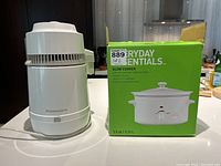 Kenmore water distiller and boxed 3.5 quart crock pot slow cooker shown side by side.