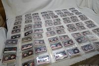 Tapes laid out flat showing many Maxell 90 minute audio cassette tapes with labels.