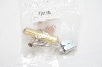 Photo of the reversing valve inside a sealed transparent plastic bag showing the valve with a metal body and hexagonal fitting end