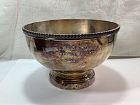 Front view of large silver plated trophy bowl showing overall shape and design.
