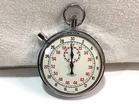 Full view of the front of the vintage Zonex stopwatch with visible dial, hands, chrome case, and loop on top.