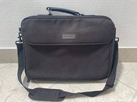 Front view of the black Compaq laptop carrying case model CQV01 showing the material, strap, and handle.