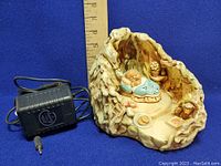 Ceramic robin's cave night light showing side angle with power adapter and ruler for size