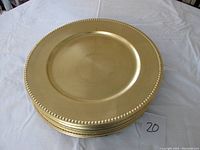 Stack of gold charger plates showing the dotted edge detail and overall shape.