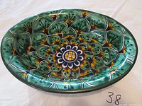Top photo showing the detailed scalloped design and colors inside the oval bowl.