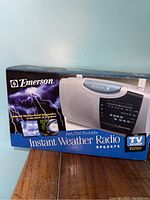 Emerson AM/FM Portable Instant Weather Radio RP6247S in original box showing the front and sides