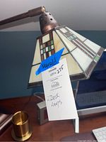 Close-up of Tiffany style stained glass shade with MaxSold tag indicating 2 desk lamps