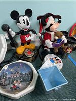 Full shot of Mickey telephone, Mickey Santa plush, commemorative plate, ceramic planter, and small Disney items