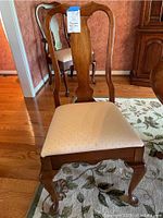 Front view of one side chair showing upholstered seat and Queen Anne style backrest