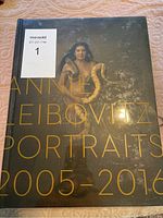 Front cover of the hardcover book featuring a portrait photograph of a woman holding two snakes, with title text.
