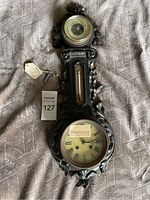 Full view of French style antique cast iron barometer and thermometer with clock and winding key