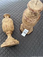 Two rustic iron candlesticks, one upright and one lying on its side, showing distressed paint finish and fluted middle design.