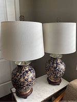 Pair of finished lamps on white top with white drum shades, showing overall style and height.