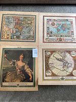 Four paper prints laid flat on floor showing vintage maps and one portrait print.